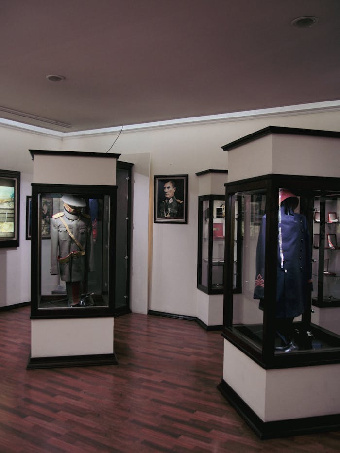 Exhibition of historical military uniforms in a museum setting, showcasing detailed displays.